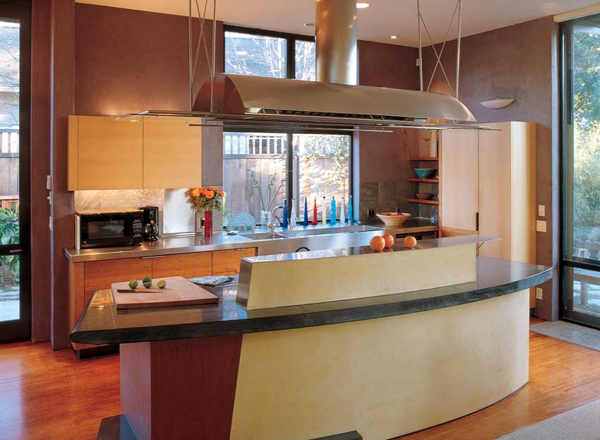 Commingling modern beauty and green design, Sandra’s kitchen boasts Plyboo, a flooring material of sustainable bamboo grass; a concrete countertop with recycled and natural objects embedded into its surface; and a built-in recycling window. The kitchen retains a functional domain of its own yet merges naturally into the communal living area—making the area ideal for entertaining. The FSC-certified cherry shelves below are functional, green, and attractive pieces in the kitchen.